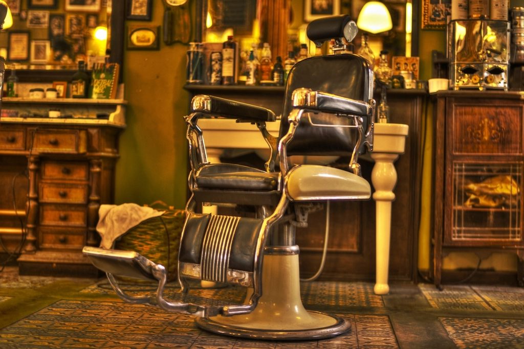 Barbershop interior shown inside a client website mockup